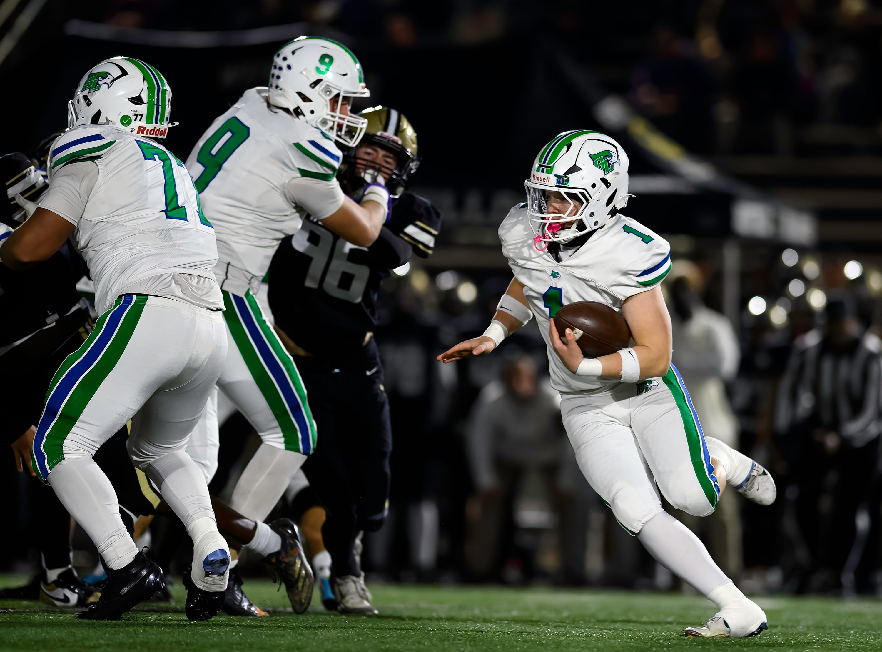 Football quarterback scrambles with blockers